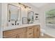 Modern bathroom with dual sinks, wood cabinets, and a large vanity area, offering style and convenience at 18205 N 18Th St, Phoenix, AZ 85022