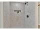 Well-lit walk-in shower features stylish tile and a convenient built-in shelf for toiletries at 18205 N 18Th St, Phoenix, AZ 85022