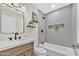 Modern bathroom with a wood vanity, decorative shelves, and a shower with grey tiling at 18205 N 18Th St, Phoenix, AZ 85022