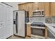 Contemporary kitchen with stainless steel appliances and light wood cabinets, maximizing space and functionality at 18205 N 18Th St, Phoenix, AZ 85022
