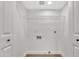 A clean, well-lit laundry room featuring white walls, tiled floor, and wire shelving for optimal storage at 18205 N 18Th St, Phoenix, AZ 85022