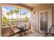 Relaxing balcony view with chairs, table, and palm trees overlooking a communal pool, perfect for outdoor enjoyment at 1941 S Pierpont Dr # 2073, Mesa, AZ 85206