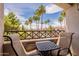 Balcony seating area featuring a table, chairs, and a scenic view of the pool and surrounding palm trees at 1941 S Pierpont Dr # 2073, Mesa, AZ 85206