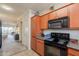 Bright kitchen features wood cabinets and modern black appliances with a view to the living area at 1941 S Pierpont Dr # 2073, Mesa, AZ 85206