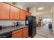 Kitchen features wood cabinets, black appliances, and a view to the living and dining areas at 1941 S Pierpont Dr # 2073, Mesa, AZ 85206