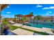 Beautiful pool featuring a pergola, orange umbrella, a deck-level fountain and ample outdoor seating under a blue sky at 19877 S 185Th Way, Queen Creek, AZ 85142