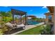 A stunning pool area with a waterfall feature, lounge chairs, and a pergola for relaxation and entertaining at 19877 S 185Th Way, Queen Creek, AZ 85142