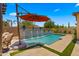 Backyard pool area featuring a waterfall feature and an orange cantilevered umbrella at 19877 S 185Th Way, Queen Creek, AZ 85142