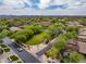 Panoramic aerial captures the serene desert community with homes nestled amongst green spaces and mountain views at 20055 N 96Th Way, Scottsdale, AZ 85255
