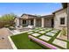 Spacious backyard featuring a stone patio, modern fire pit, artificial turf, and elegant outdoor furniture at 20055 N 96Th Way, Scottsdale, AZ 85255