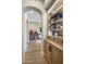 Hallway with light wood floors, recessed lights, arched entryway, and built-in bookcase at 20055 N 96Th Way, Scottsdale, AZ 85255