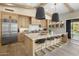Spacious kitchen featuring wood cabinets, a large island with barstool seating, and stainless steel appliances at 20055 N 96Th Way, Scottsdale, AZ 85255