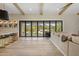 Bright living room with hardwood floors, exposed beam ceilings, and expansive glass doors to the backyard at 20055 N 96Th Way, Scottsdale, AZ 85255