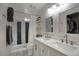 Bathroom with double sink vanity, marble countertops, and shower-tub combo with updated fixtures at 2020 W Union Hills Dr # 110, Phoenix, AZ 85027