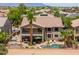 A resort-style backyard with a pool, spa, lounge area, outdoor kitchen and a covered patio at 21841 N Ingram Ct, Maricopa, AZ 85138