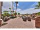 Expansive backyard featuring a brick patio, built-in seating, a lush landscape and plenty of palm trees at 21841 N Ingram Ct, Maricopa, AZ 85138