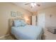 A serene bedroom featuring a comfortable bed with blue accents, a ceiling fan, and a stylish accent table at 21841 N Ingram Ct, Maricopa, AZ 85138