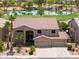 Stunning home showcasing a well-manicured lawn, mature palms and a view overlooking a lush golf course at 21841 N Ingram Ct, Maricopa, AZ 85138