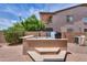 Backyard hot tub with stone trim, patio and a peek at an outdoor grill at 21841 N Ingram Ct, Maricopa, AZ 85138
