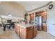 Kitchen island with granite countertop, wooden cabinetry, and views of the breakfast nook and second story at 21841 N Ingram Ct, Maricopa, AZ 85138