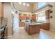 Well-lit kitchen with granite countertops, wooden cabinetry, stainless steel appliances, and an island at 21841 N Ingram Ct, Maricopa, AZ 85138