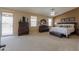 Expansive main bedroom with dark wood furniture, large windows, and plush carpeting for a comfortable retreat at 21841 N Ingram Ct, Maricopa, AZ 85138