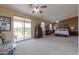 Spacious primary bedroom boasts plush carpet, a private balcony, dark wood furniture, and ample natural light at 21841 N Ingram Ct, Maricopa, AZ 85138