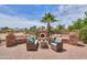 Outdoor living space with comfortable seating, a decorative stone fireplace, and a beautifully paved patio at 21841 N Ingram Ct, Maricopa, AZ 85138