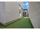 Narrow backyard featuring artificial turf with putting green leading to a charming pergola covered patio at 226 E Markwood Dr, Chandler, AZ 85286