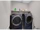 This laundry room features a full-size washer and dryer, and upper shelving for storage of supplies at 226 E Markwood Dr, Chandler, AZ 85286