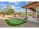 This backyard features a putting green, pool with waterfall, and covered patio seating area at 24645 N 117Th St, Scottsdale, AZ 85255