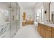 Bright open bathroom with luxurious glass shower, vanity and a free-standing tub next to large windows at 24645 N 117Th St, Scottsdale, AZ 85255