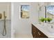 Bright bathroom boasts double vanity, modern fixtures, and window view to the lush greenery outside at 24645 N 117Th St, Scottsdale, AZ 85255