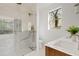 Bathroom featuring a walk-in shower with glass door, wood vanity, and bright natural light at 24645 N 117Th St, Scottsdale, AZ 85255