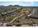 Expansive aerial view of a Primary-planned community with a golf course nestled against a mountainous backdrop at 25971 W Taro Dr, Buckeye, AZ 85396