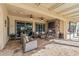 Spacious covered patio featuring a stone fireplace, TV, and comfortable seating at 25971 W Taro Dr, Buckeye, AZ 85396