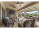 Wide angle view of a covered patio with an outdoor kitchen, stone fireplace, and seating at 25971 W Taro Dr, Buckeye, AZ 85396
