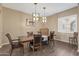 Traditional dining room with wooden table, chairs, and modern light fixtures at 25971 W Taro Dr, Buckeye, AZ 85396