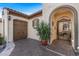 Covered entryway with brick-paver driveway leading to a gated courtyard and attached two-car garage at 25971 W Taro Dr, Buckeye, AZ 85396