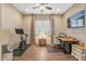 Versatile office space with desk, seating, workout bike, and natural light, creating a productive work environment at 25971 W Taro Dr, Buckeye, AZ 85396