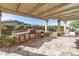 This covered patio features a built-in outdoor kitchen with a grill, mini fridge, and ample counter space at 25971 W Taro Dr, Buckeye, AZ 85396