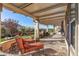Inviting covered patio complete with lounge chairs and a custom built-in stone seating area, perfect for relaxation at 25971 W Taro Dr, Buckeye, AZ 85396