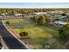 Aerial shot of a residential area with a grassy field and tree-lined street at 2619 E Jerome Ave, Mesa, AZ 85204