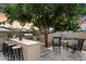 Inviting backyard featuring an outdoor kitchen and bar with ample seating, ideal for gatherings at 2619 E Jerome Ave, Mesa, AZ 85204