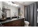 Bathroom with dark wood cabinets, granite countertops, decorative mirror and a shower/tub combination at 2619 E Jerome Ave, Mesa, AZ 85204
