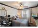 Inviting bedroom with a cozy bed and ceiling fan, complemented by a drum set and a mounted TV at 2619 E Jerome Ave, Mesa, AZ 85204