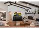 Spacious living room featuring beamed ceilings, a brick fireplace, and comfortable seating at 2619 E Jerome Ave, Mesa, AZ 85204
