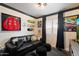 A cozy living room features a black leather sofa, unique decor, and a window providing natural light at 2619 E Jerome Ave, Mesa, AZ 85204