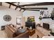 Bright living room featuring beamed ceilings, a brick fireplace, and a comfortable leather sectional at 2619 E Jerome Ave, Mesa, AZ 85204