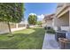 Backyard featuring lush green grass, mature trees, and private fencing at 2801 N Litchfield Rd # 65, Goodyear, AZ 85395